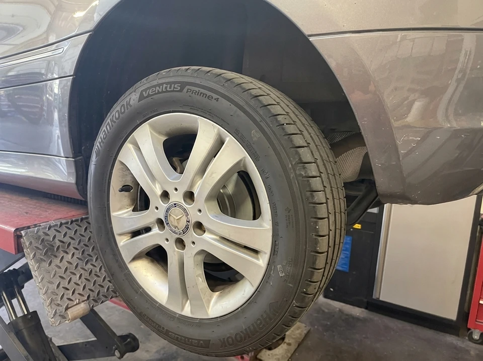 Garage automobile intérieur, Peugeot 308 noire sur pont élévateur à ciseaux, capot ouvert