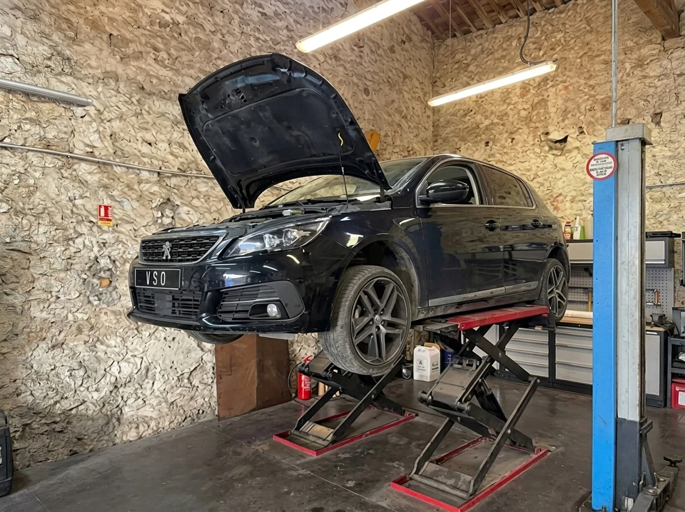 Garage automobile, intérieur, véhicule SUV Škoda Kodiaq noir immatriculé "WSO" positionné sur pont élévateur à colonnes