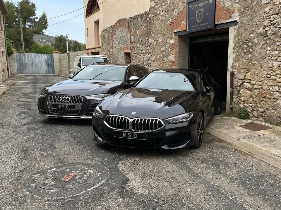 Garage mécanique en pierre, élévateur à deux colonnes soulevant un SUV Mercedes-Benz GLC noir (W253), capot ouvert